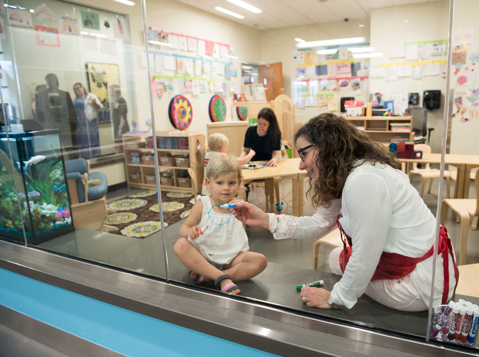 Child and Caretaker drawing on glass